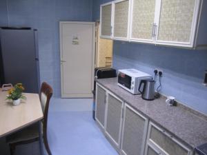 a kitchen with a counter with a microwave and a table at العين الهيلي مصباح ب 2 in Al Ain