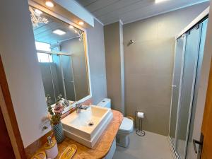 a bathroom with a sink and a toilet and a mirror at Rua Capitao Eleuterio, 210 - Centro · SI Belo Apto – Próx. HSVP e Hospital de Clínicas in Passo Fundo
