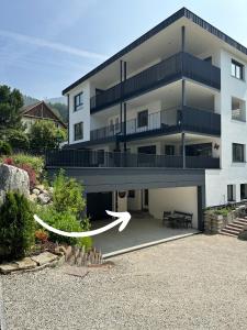 Un edificio blanco con una flecha blanca delante. en Apartment Wörer, en Perca