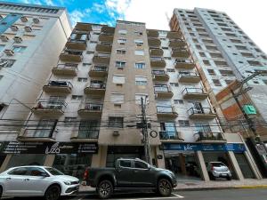 a truck parked in front of a tall building at Rua Capitao Eleuterio, 210 - Centro · SI Belo Apto – Próx. HSVP e Hospital de Clínicas in Passo Fundo