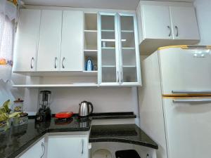 a kitchen with white cabinets and a white refrigerator at Rua Capitao Eleuterio, 210 - Centro · SI Belo Apto – Próx. HSVP e Hospital de Clínicas in Passo Fundo +39 photos