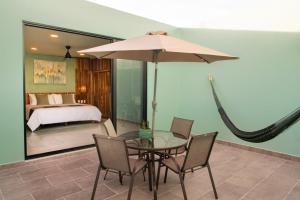 een tafel met stoelen en een parasol in een slaapkamer bij Luuna de Jade in Oaxaca City +10 foto's