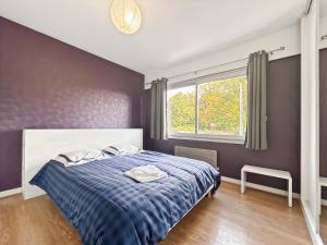 a bedroom with a blue and white bed with a window at Confort et Bien-être in Désertines
