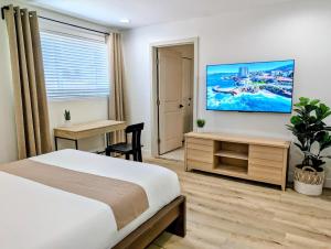 a bedroom with a bed and a tv on the wall at Designer's Touch in San Diego