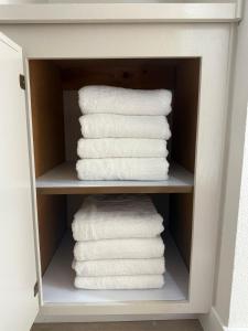a stack of white towels in a cabinet at Designer's Touch in San Diego