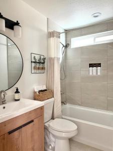 a bathroom with a toilet and a sink and a tub at Designer's Touch in San Diego