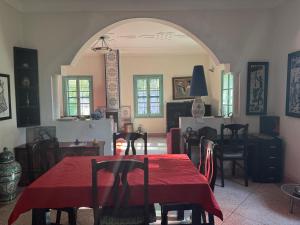 a dining room with a red table and chairs at Villa Zaïtoun in Aït Ourir