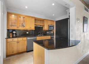 Orange HillWaterfront Relaxation with Stunning Views的厨房配有木制橱柜和黑色台面