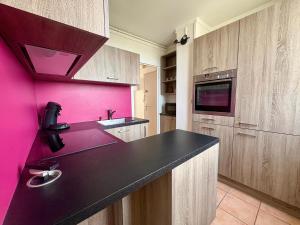 ルマンにあるSuperbe appt 3 ch à 2 pas du circuit des 24Hのピンクの壁のキッチン(黒いカウンタートップ付) +8枚の写真