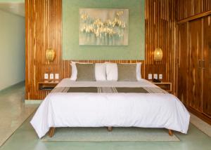 een slaapkamer met een groot wit bed en houten wanden bij Luuna de Jade in Oaxaca City