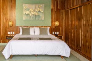een slaapkamer met een groot wit bed en houten wanden bij Luuna de Jade in Oaxaca City