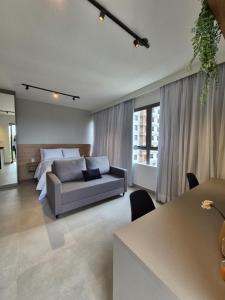 una sala de estar con un sofá y una cama en STÚDIO - Novo e Sofisticado!, en Princesa dʼOeste