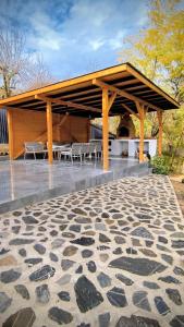 a pavilion with chairs and rocks on a patio at Casa Runcu Dambovita in Bădeni