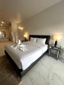 a bedroom with a large white bed with a stuffed animal on it at Replay F405 By S&p Villa Management in Amphoe Koh Samui +18 photos