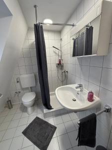 a white bathroom with a sink and a toilet at Der OXE am Maindreieck in Niederdorla