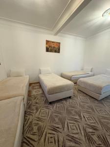 a room with three beds and a painting on the wall at Daryussef 114 in Marrakech +17 photos