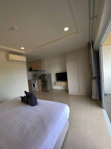 a bedroom with a large white bed and a kitchen at The Terraza A212 - Cozy Apartment By Sp Villa in Amphoe Koh Samui