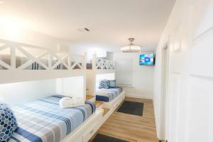 パナマ・シティ・ビーチにあるStunning 4BD Jacuzzi - 4 Min To Beach Panama Cityのベッドルーム(ベッド2台、テレビ付)