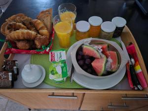 a tray of food with a bowl of fruit and pastries at Au petit bonheur in Hautefage-la-Tour