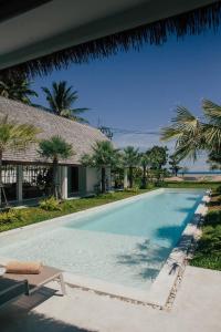 una piscina frente a una casa en Villa Aditi - Amazing Beachfront Villa, en Nathon Bay