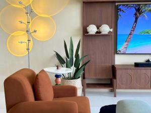 a living room with two chairs and a flat screen tv at Villa La Lay By S&p Villa Management in Ban Tai