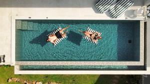 two people are swimming in a swimming pool at Villa La Lay By S&p Villa Management in Ban Tai
