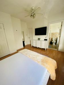 een slaapkamer met een wit bed en een flatscreen-tv bij Private bathroom inside Master bedroom! in Paterson