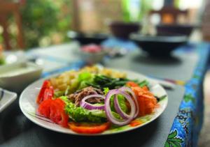 a plate of food with vegetables on a table at Hotel Eyram Kpalime in Palimé +19 photos