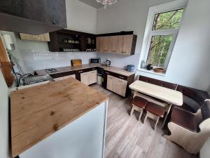a kitchen with a wooden table and a counter top at Toma pirts LIELĀ in Ikšķile