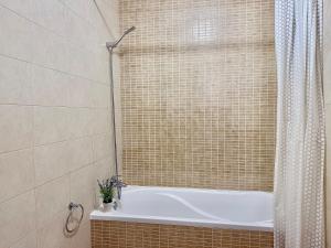 ein Badezimmer mit einer Badewanne mit Duschvorhang in der Unterkunft Nazaré Beach Apartments in Nazaré