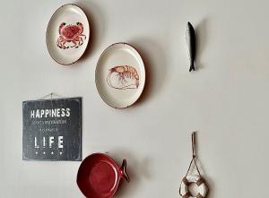 eine Wand mit Tellern und Utensilien an der Wand in der Unterkunft Nazaré Beach Apartments in Nazaré