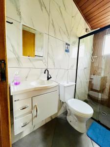 a white bathroom with a toilet and a sink at Estalagem Bernardinos in Camanducaia +24 photos