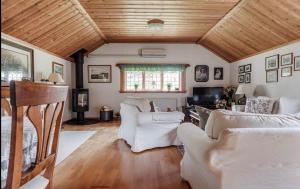 uma sala de estar com móveis brancos e teto de madeira em Ein großes Hausam Wald mit Bach für 8 Personen 