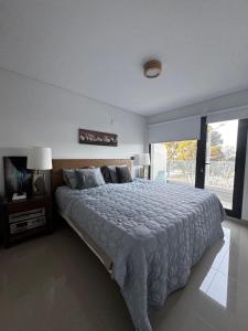 ein Schlafzimmer mit einem großen Bett und einem großen Fenster in der Unterkunft PLAYA - Alojamiento frente al mar in Puerto Madryn
