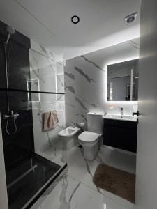 ein Badezimmer mit Toilette, Waschbecken und Dusche in der Unterkunft PLAYA - Alojamiento frente al mar in Puerto Madryn