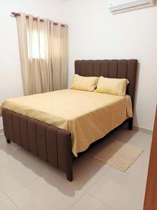 a bed in a bedroom with a brown bed frame at Sunrise Apartments in San Felipe de Puerto Plata +25 photos