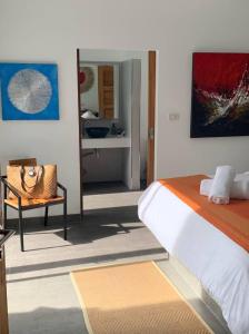 a bedroom with a bed and a chair and a bathroom at Villa Natao by SP Villa Management in Mae Nam