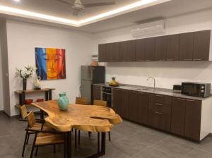 a kitchen with a wooden table and a dining room at Villa Natao by SP Villa Management in Mae Nam +6 photos