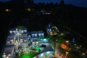 坎波斯杜若尔当vila grega hotel boutique的夜幕降临，从空中俯瞰一座带有水上乐园的房屋