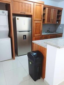 a kitchen with a refrigerator and a trash can at Sunrise Apartments in San Felipe de Puerto Plata