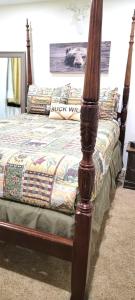 a bed with a wooden post in a bedroom at ManVee at Yosemite in Fish Camp