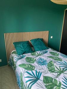 a bed with two blue pillows on top of it at Le Hameau des Lavandes in Roynac