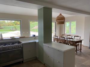 a kitchen with a stove and a table with chairs at Le Hameau des Lavandes in Roynac