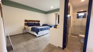 a bedroom with a bed and a bathroom with a toilet at Boulevard Pousada Boutique in Guaramiranga +21 photos