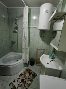 a bathroom with a tub and a toilet and a sink at City Apartman in Subotica