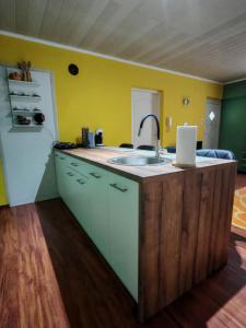 a kitchen with a sink and a laptop on a counter at City Apartman in Subotica