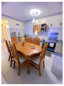 einen hölzernen Esstisch und Stühle in der Küche in der Unterkunft Luxurious Pavilion Nest in Mombasa
