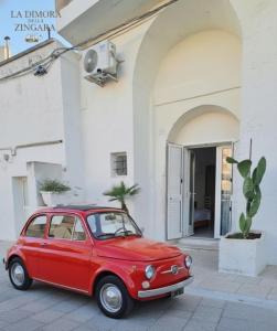 a red car parked in front of a building at La Dimora dellaZingara in Statte