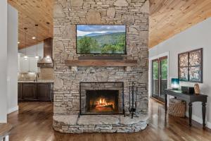 - une cheminée en pierre dans le salon avec une fenêtre dans l'établissement Starlight Ridge, à Seven Devils