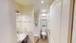 a white bathroom with a toilet and a sink at Les Meublés d'Etigny in Luchon +41 photos